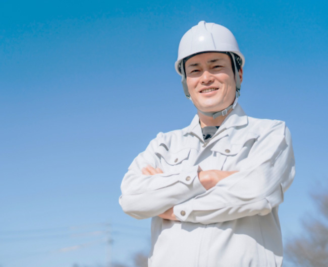 笑顔で腕を組む職人